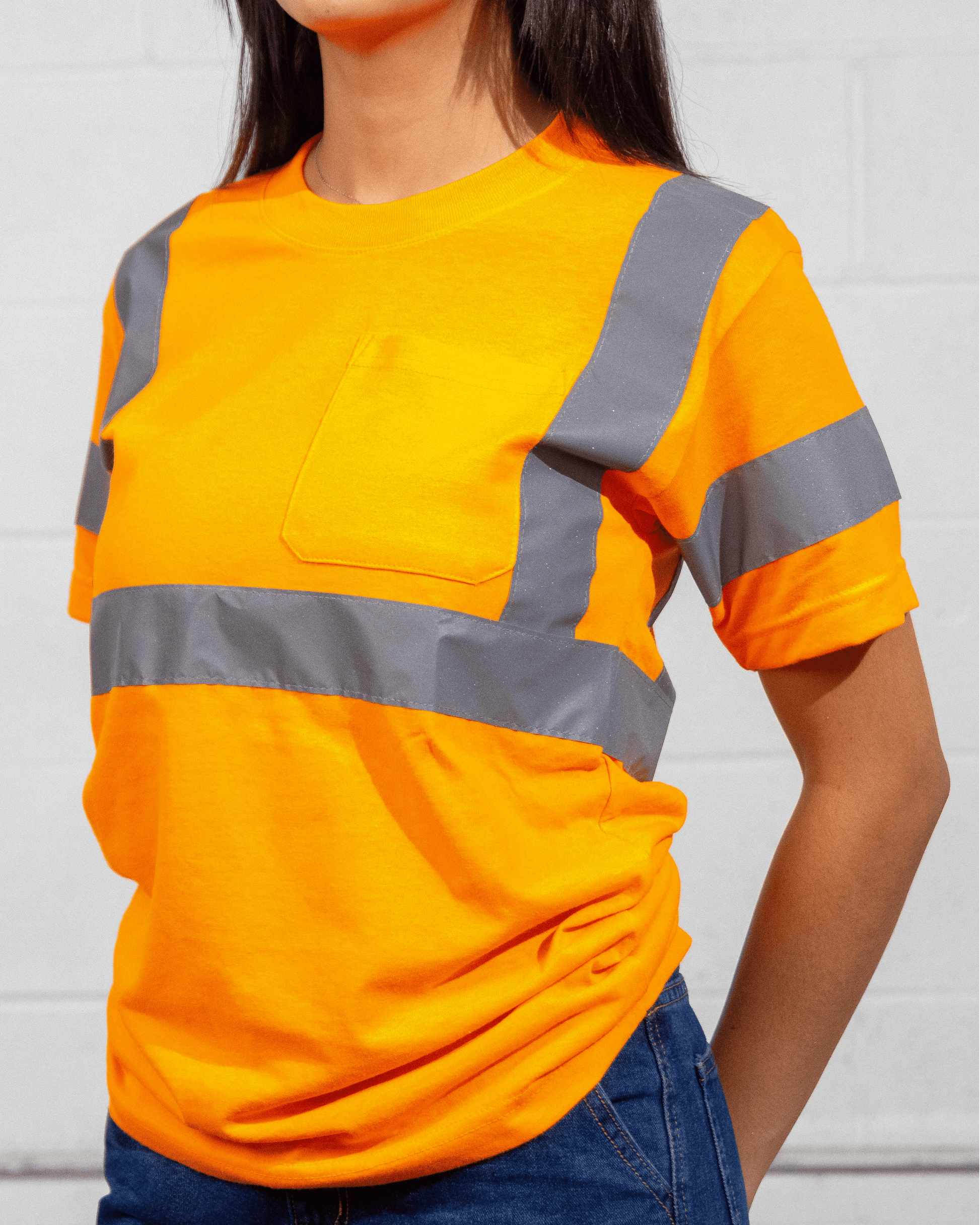 A woman wearing a Suna Cotton® Safety Orange Reflective T-shirt